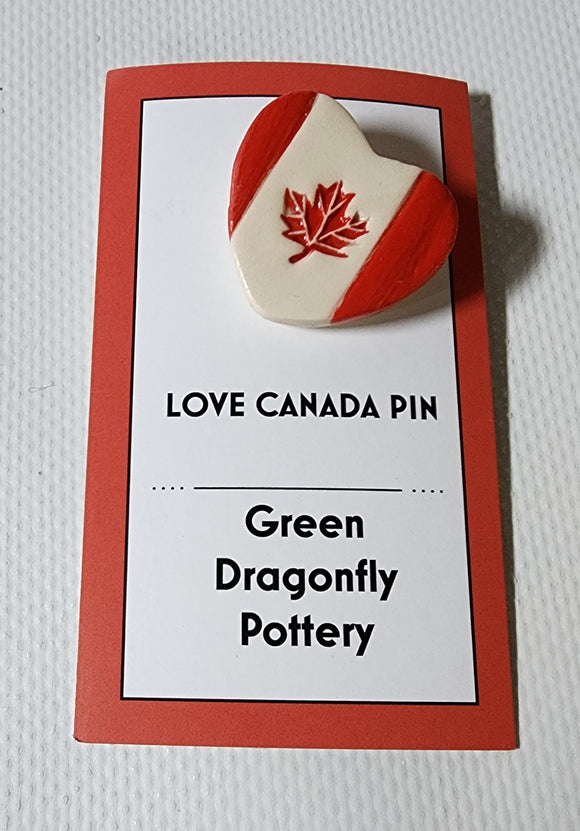 Heart shaped pin with maple leaf.